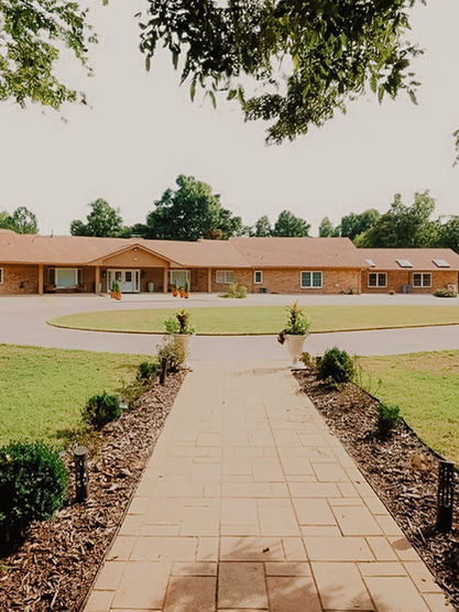 Long, low-slung building with circular drive and well-manicured lawn, Pecan Garden Estate.