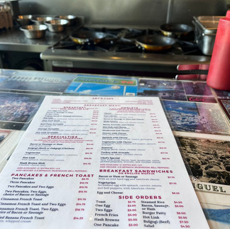 Art's Cafe diner menu on a counter covered in post cards