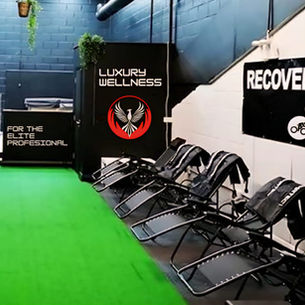 Ignisvita-branded recovery room designed for elite athletes, equipped with advanced compression therapy chairs, professional wellness signage, and a green turf floor to promote optimal post-competition healing and recovery.