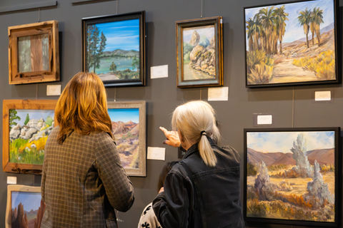 People looking at paintings in a gallery 