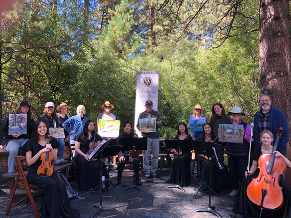 string players and artists smiling in a circle