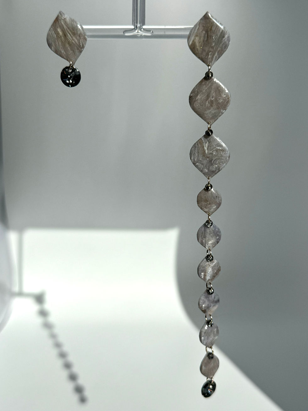 asymmetrical grey extra long earrings with crystals and gold at white background