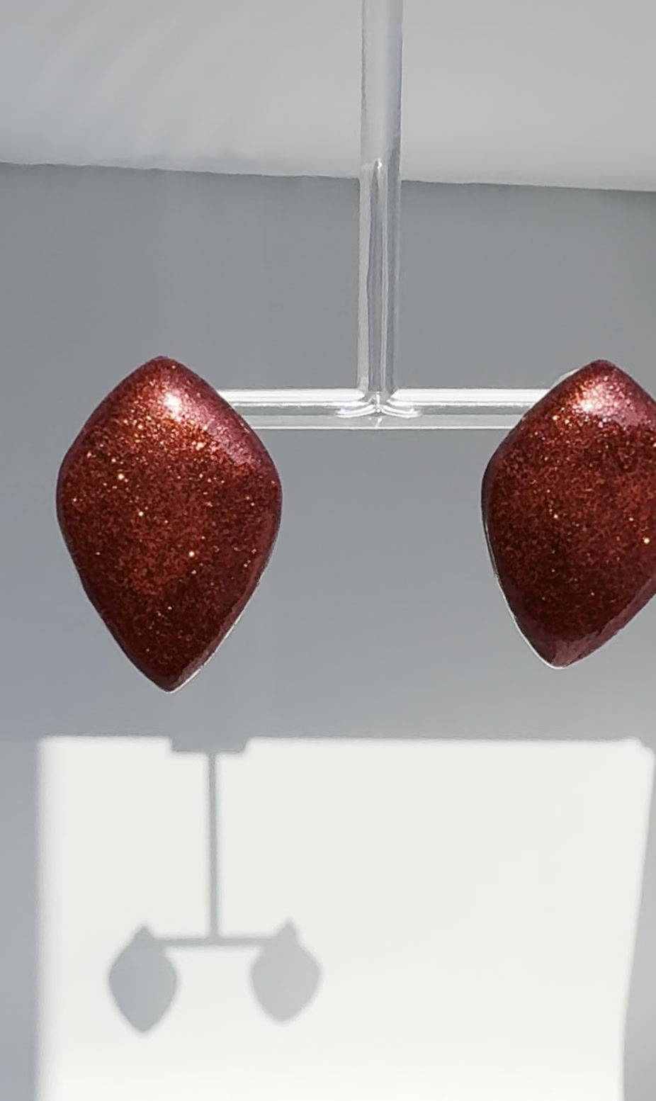 Balloon Petal Glittery Burgundy earrings Bijoux Vii Idea Collection on the earring stand