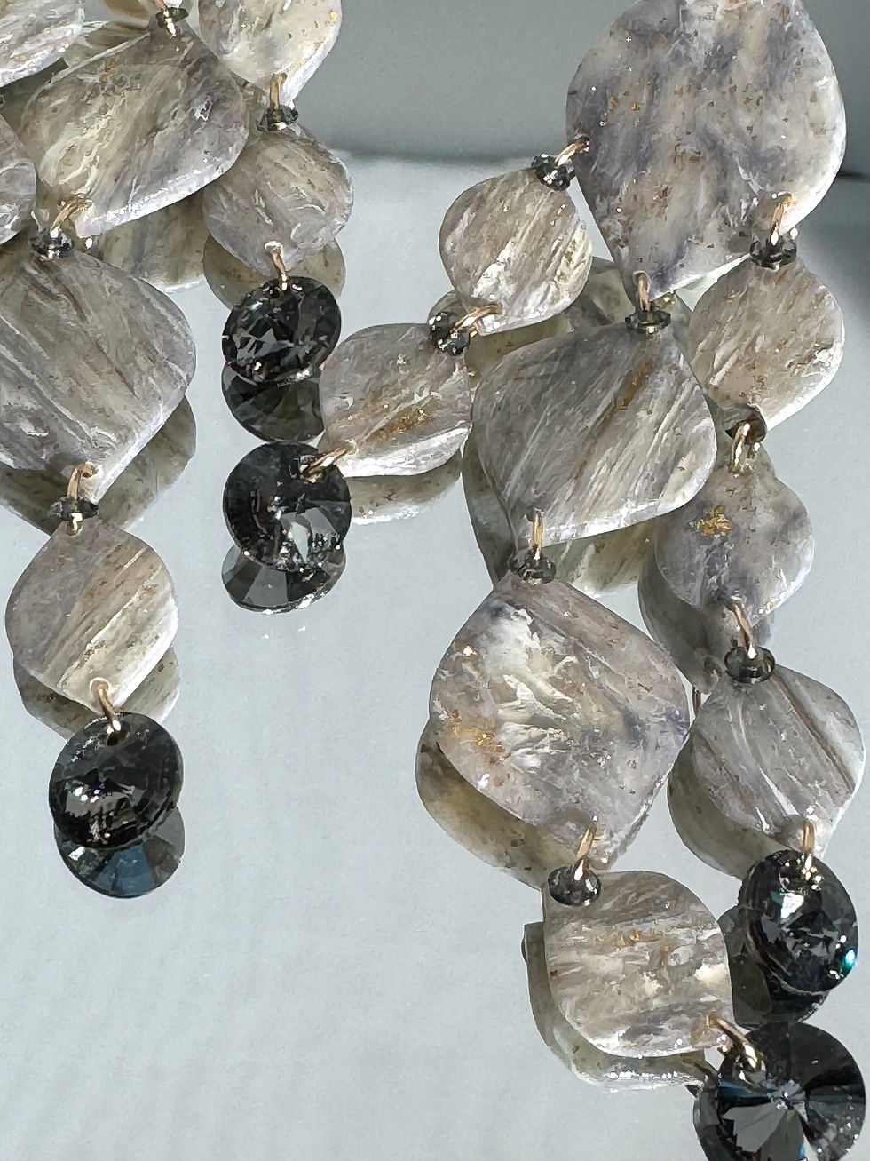 detail of statement grey earrings Bijoux Vii, gold, polymer clay and Swarovski crystals