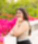 Joven mujer sonriendo posando cerca de flores