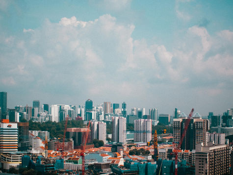 Singapore skyline with residential buildings and construction cranes, representing BTO or private property options.