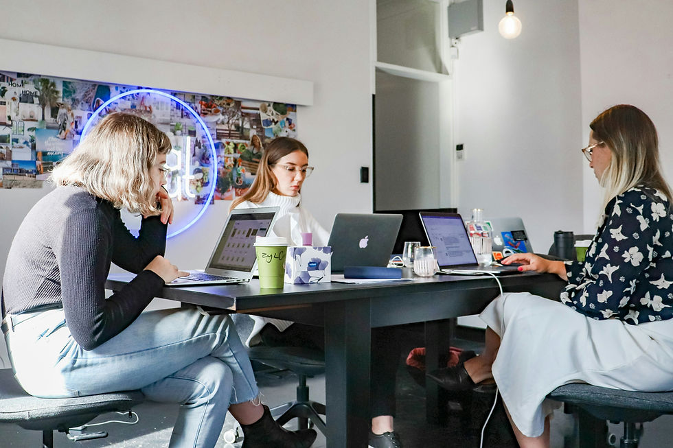 Three professionals collaborating on laptops in a modern office, discussing the advantages of Australia affiliate marketing such as ROI efficiency, new customer segments, and strategic insights for sustainable brand expansion in 2026.