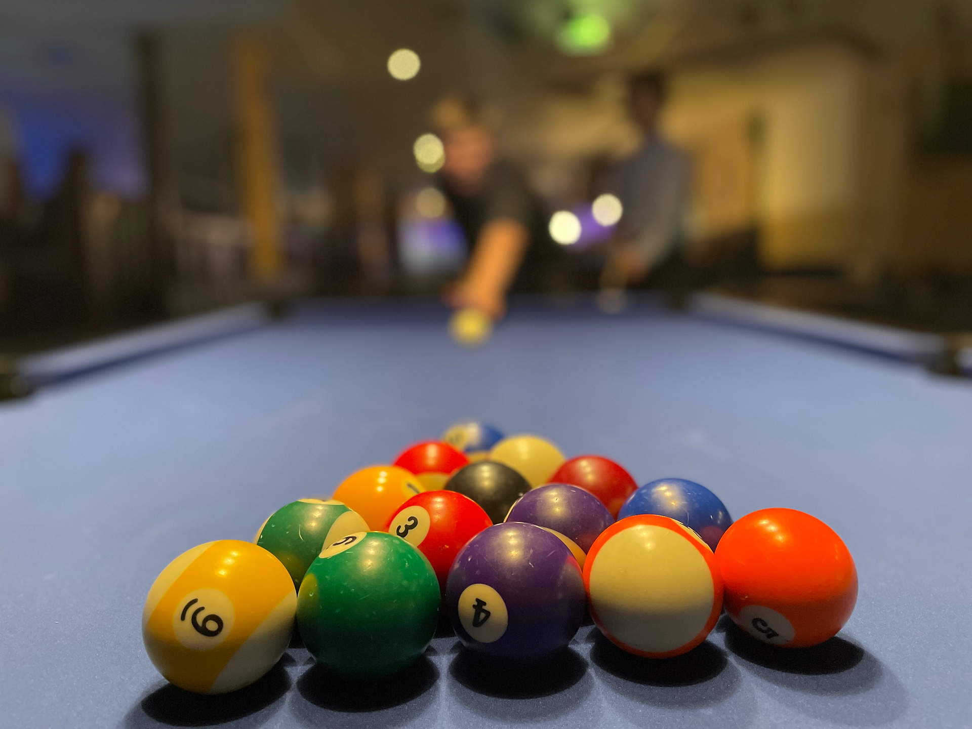 Group of students playing pool in the youth hostel common room.