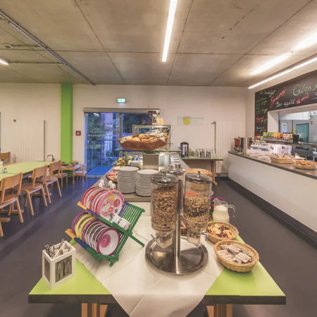 Speiseraum der Jugendherberge mit Schulgruppe beim Essen auf Englisch-Klassenfahrt.