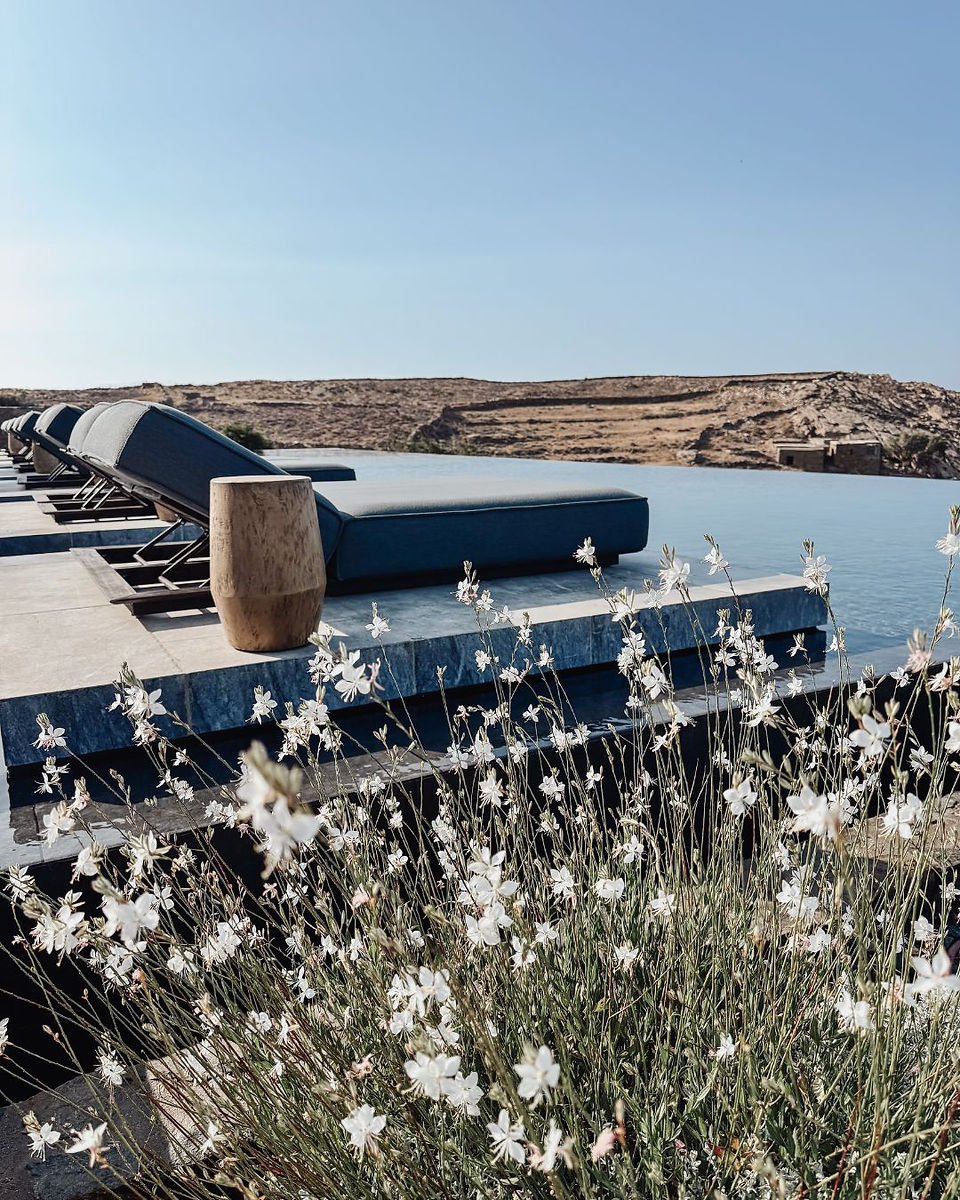 Ligbedden bij het zwembad van Odera Tinos met uitzicht op de baai