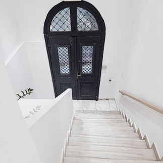 Mooie witte hal met marmeren trap bij Syros Soul suites