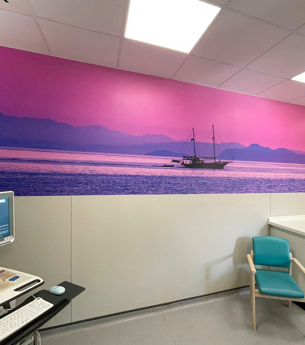 Landscape photograph wall mural of a sailing boat at sea. Dusk time with pink skies