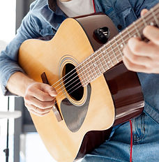 Man strumming a wooden guitar