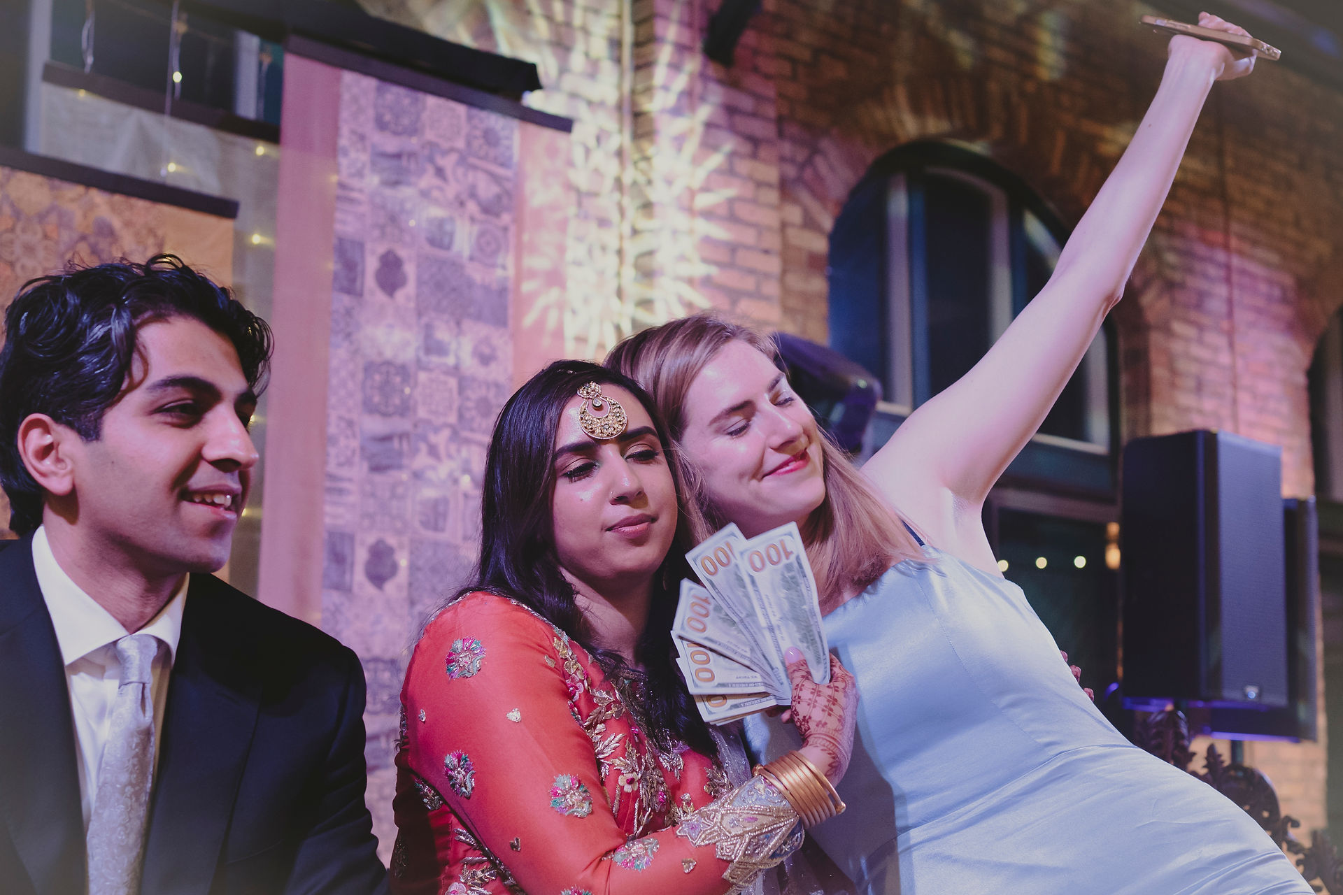Beautiful South Asian bride and her family receiving money from groom’s family during fun wedding custom in Ontario, a joyful tradition everyone enjoys