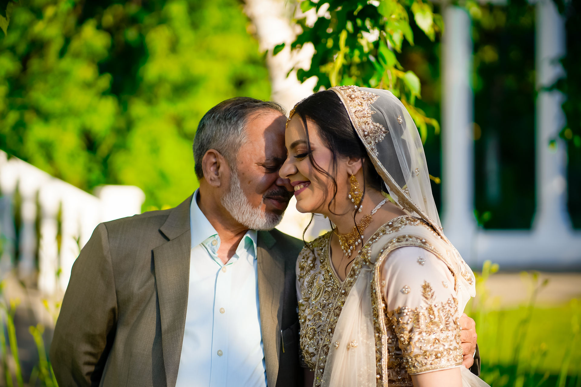 Emotional South Asian bride hugging her father as he admires her beauty during wedding day in Ontario, candid moment captured by professional wedding photographer in Toronto, Brampton, and Mississauga
