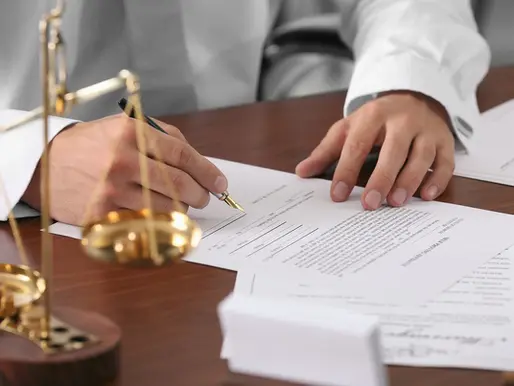 Attorney signing document at his desk