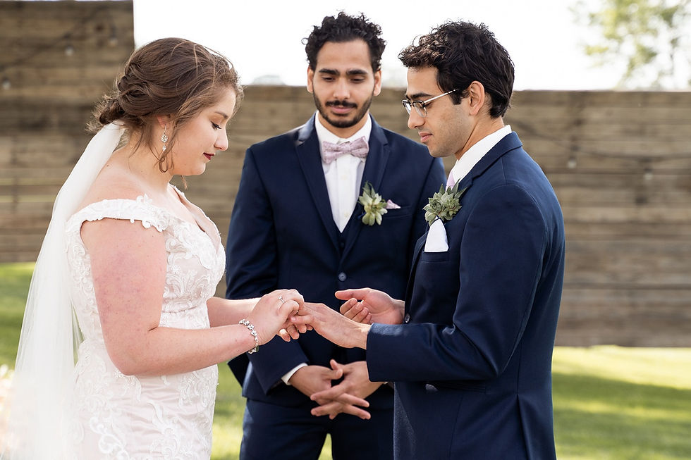 bride and groom exchanging rings during wedding ceremony at little lights on the lane