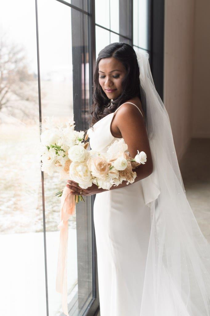 Bride at Little Lights on the Lane in West Branch holding white neutral bridal bouquet by Studio Bloom Iowa wedding florist