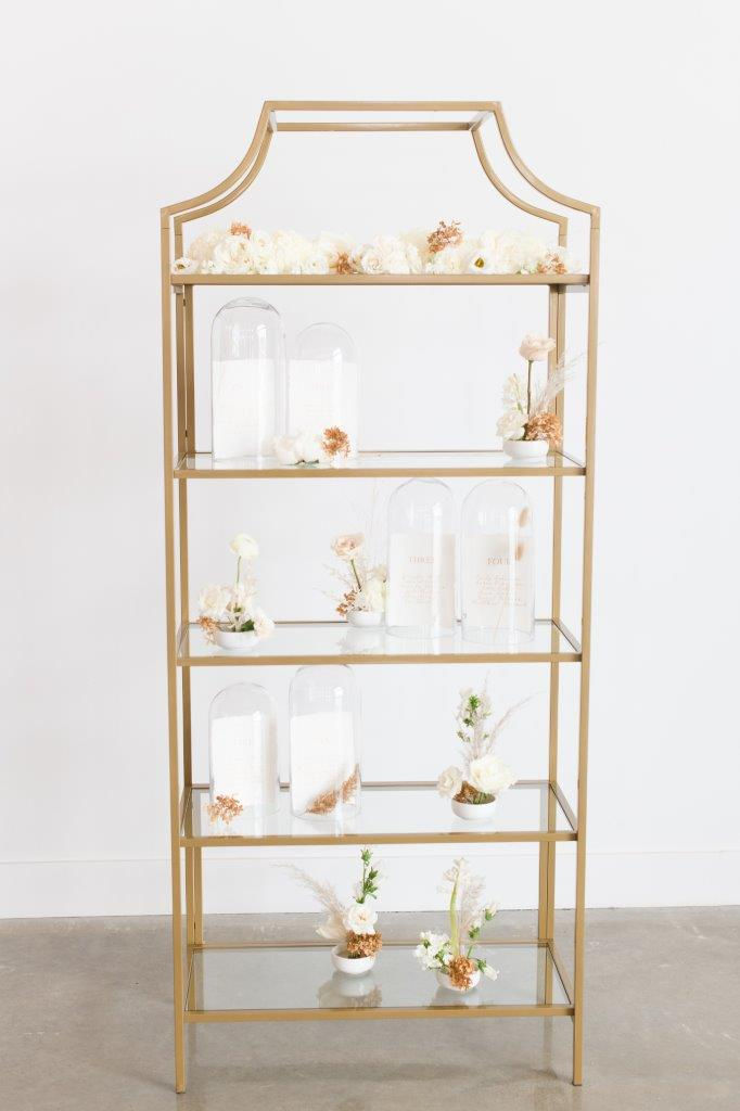 Wedding seating chart on shelf with calligraphy inside glass cloche domes and minimalist flowers by studio bloom iowa