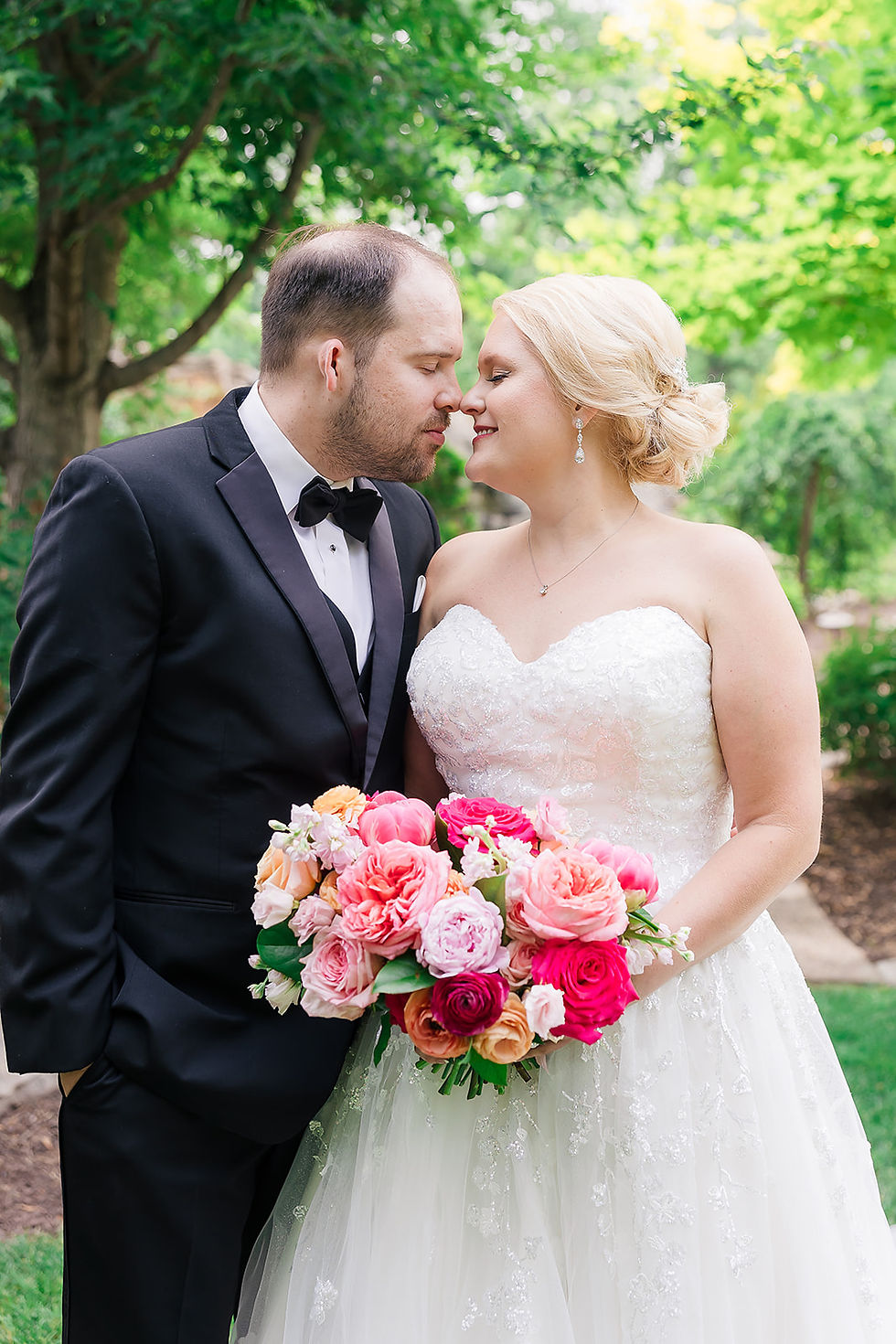 bride and groom with bridal bouquet in pink and peach by Studio Bloom wedding florist