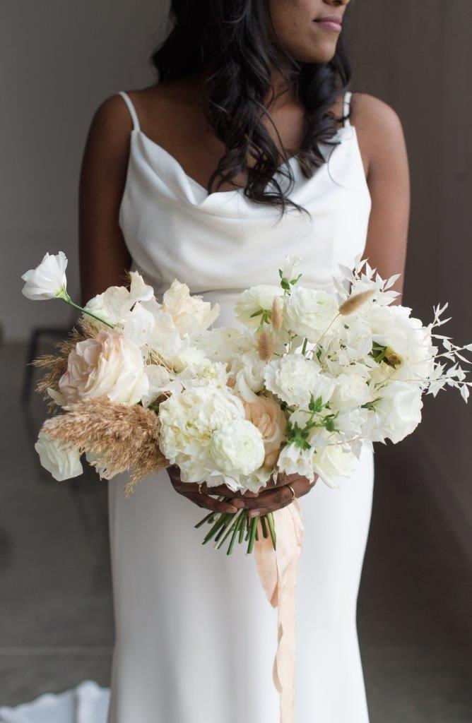 Fine art white bridal bouquet by Studio Bloom Iowa wedding designer with garden roses, peonies, ranunculus, and pampas