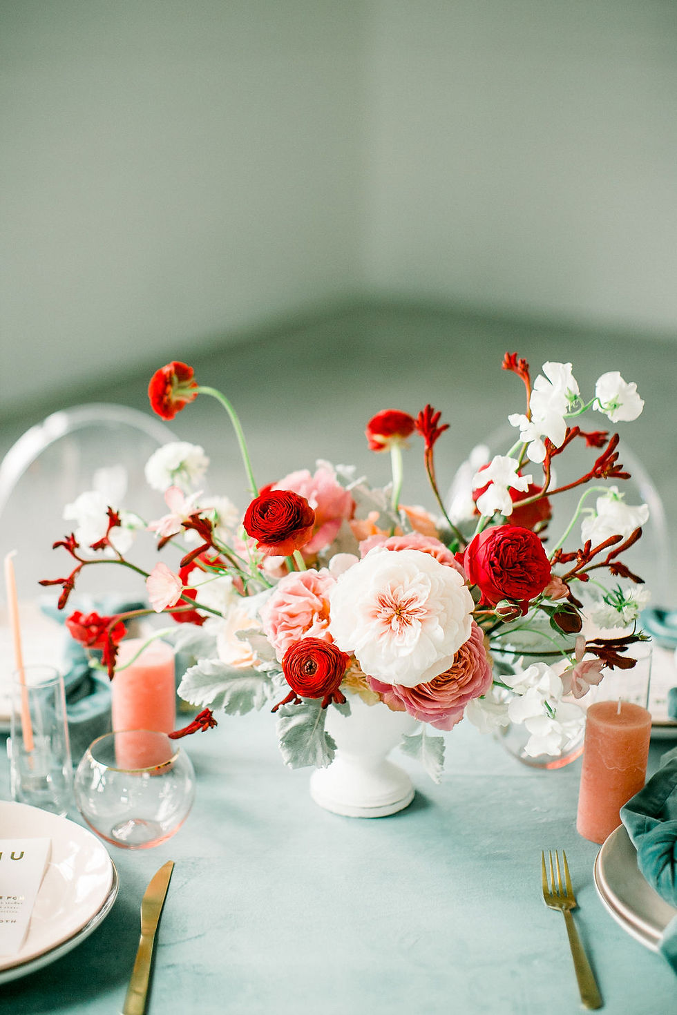 Modern centerpiece by Studio Bloom Iowa wedding florist in red, blush, and teal with garden roses, ranunculus, and sweet pea