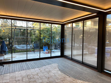 Modern bioclimatic pergola with glass walls and LED lighting.