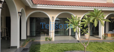 Modern villa exterior with white arched patio and lawn