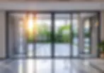 Modern black sliding glass doors overlooking a sunny patio.