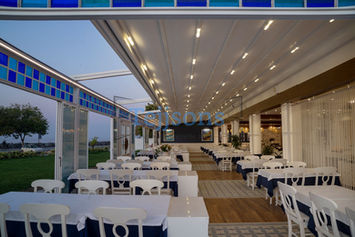 Outdoor restaurant terrace with a lit retractable pergola.