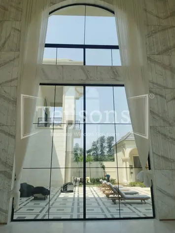 Large floor-to-ceiling windows overlooking a poolside patio
