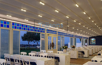 Retractable pergola with LED lights over a dining area