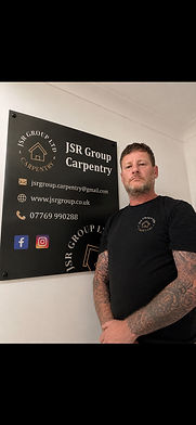 JSM Group Carpentry owner standing by company sign