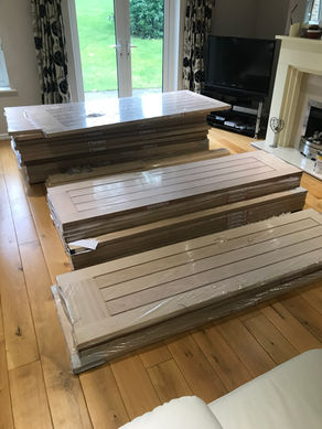Stacks of new wooden interior doors on a wood floor