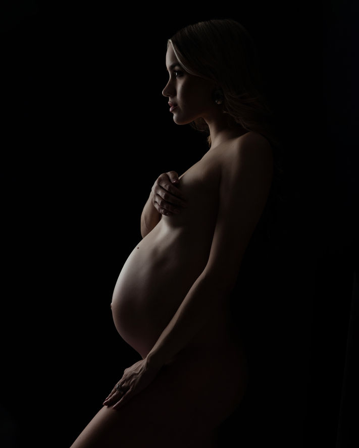 Artistic maternity photography with moody lighting