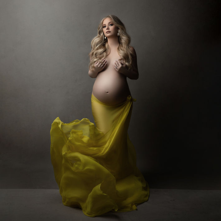 Couture maternity photography session with styled backdrop