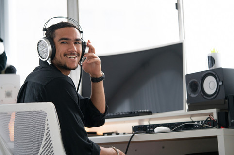 a man wearing headphones sitting in front of a computer