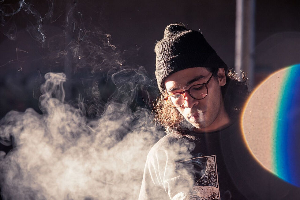 Juno exhales smoke from his nose, creating a visually captivating scene representing the artistry of music production and Dallas marketing.