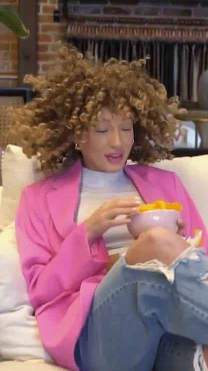 Super model eats chips messy style and wipes Cheeto dust on couch for influencer video marketing campaign. 