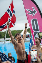 Extreme sports event still featuring a diver suspended mid-air above open water during live competition.