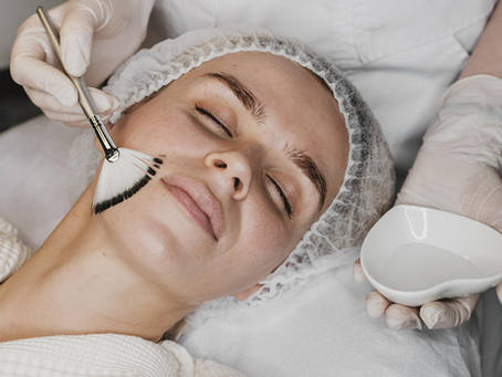 Professional esthetician performing a facial treatment on a client during acne care session