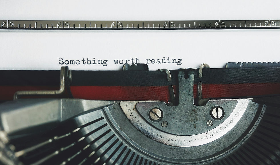 Detail of a typewriter and a sheet of paper with the words “Something worth reading”