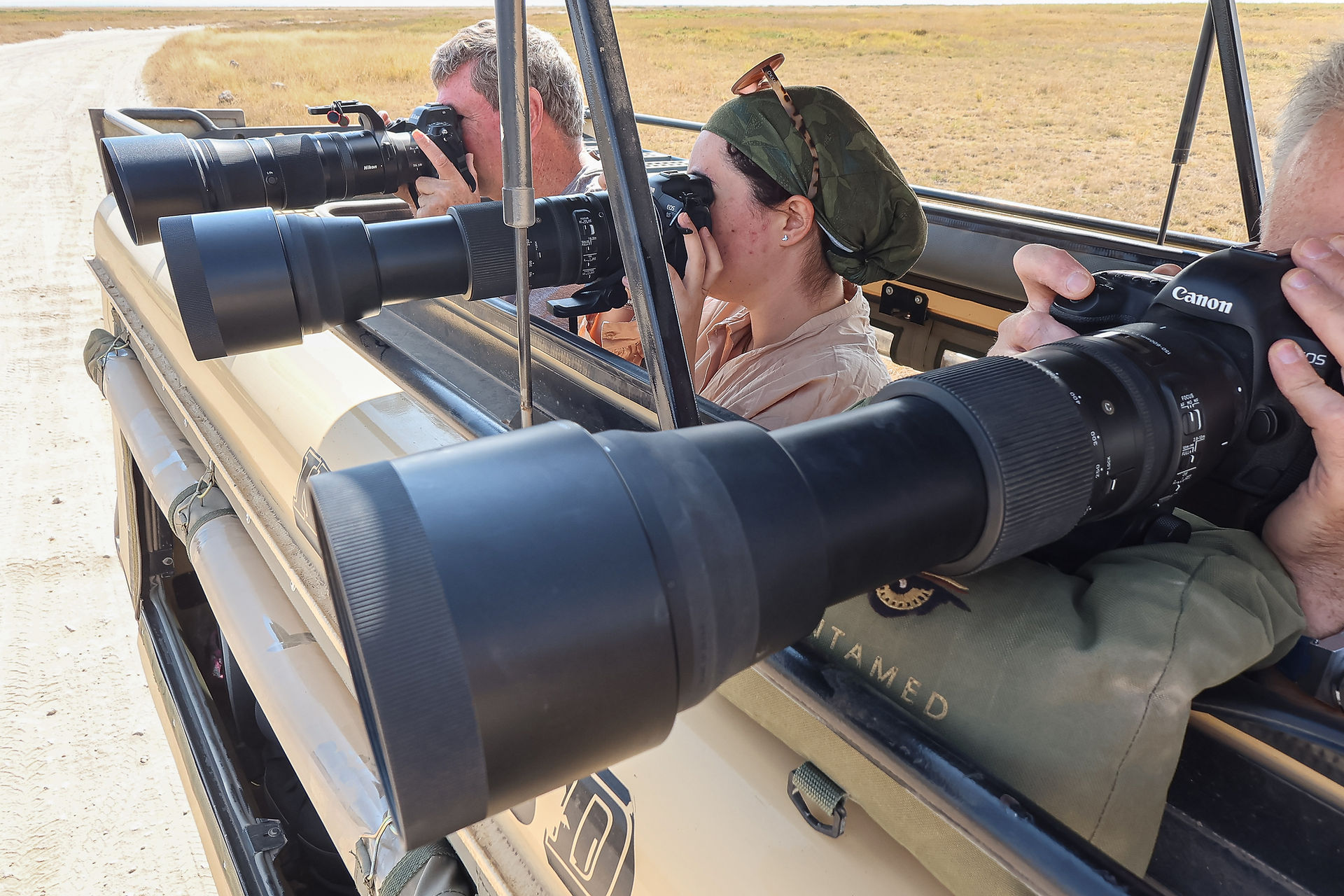 Photographers with telephoto lenses in a safari vehicle in Amboseli National Park