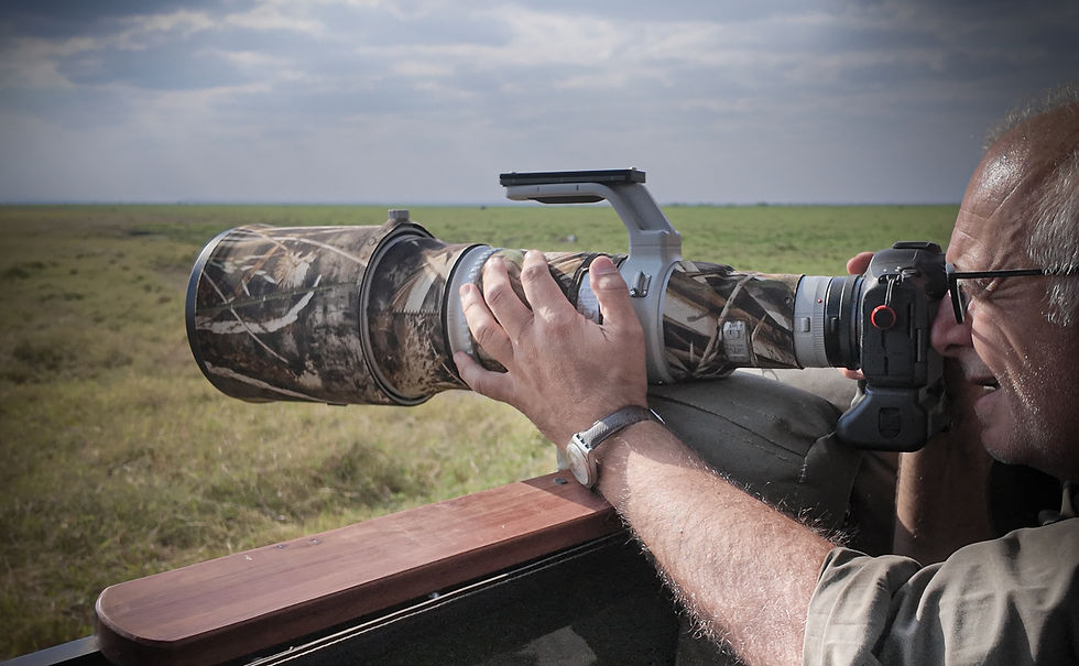 A wildlife photography guest of Untamed Photo Safaris, looks through his camera and photographs wildlife of Ndutu in the south of the Serengeti.