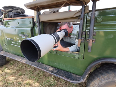 wildlife photographer with a Canon EF 500mm f4l IS II USM Lens in a safari truck in the Masai Mara