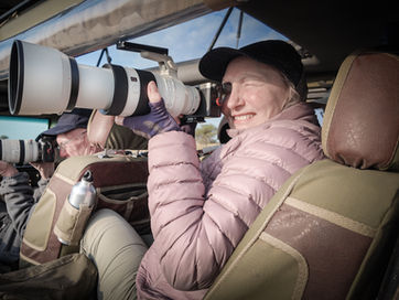 Wildlife photographers on a photographic safari tour with Untamed Photo Safaris using a 100-500mm Canon zoom lens to photograph the Great Migration of Tanzania in a photographic safari vehicle with Mark A Fernley