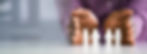 Small generic figurines of people on a table, a person h olding their hands on each side of the display
