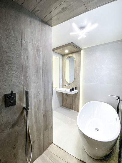 Une salle de bain avec grands carreaux en grès cérame Porcelanosa, bois et béton à Le Chesnay