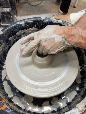 pulling clay on pottery wheel