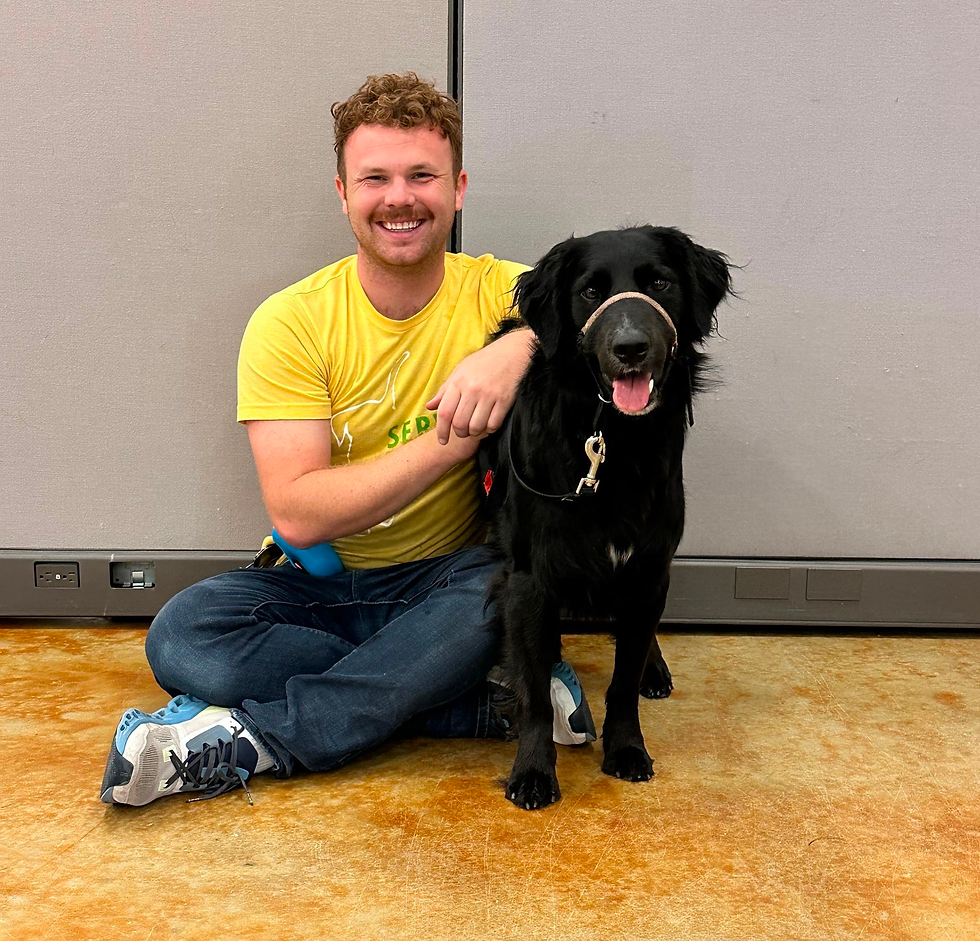 Man and dog pose for a portrait while sitting on the floor together.